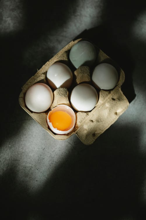 Set of fresh raw white eggs in cardboard box