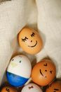 Top view of colorful chicken eggs painted with felt pens placed on fabric during Easter holiday at home in kitchen