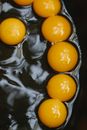 Top view abundance of quail eggs with yellow yolks cooking in black pan during breakfast preparation in kitchen at home