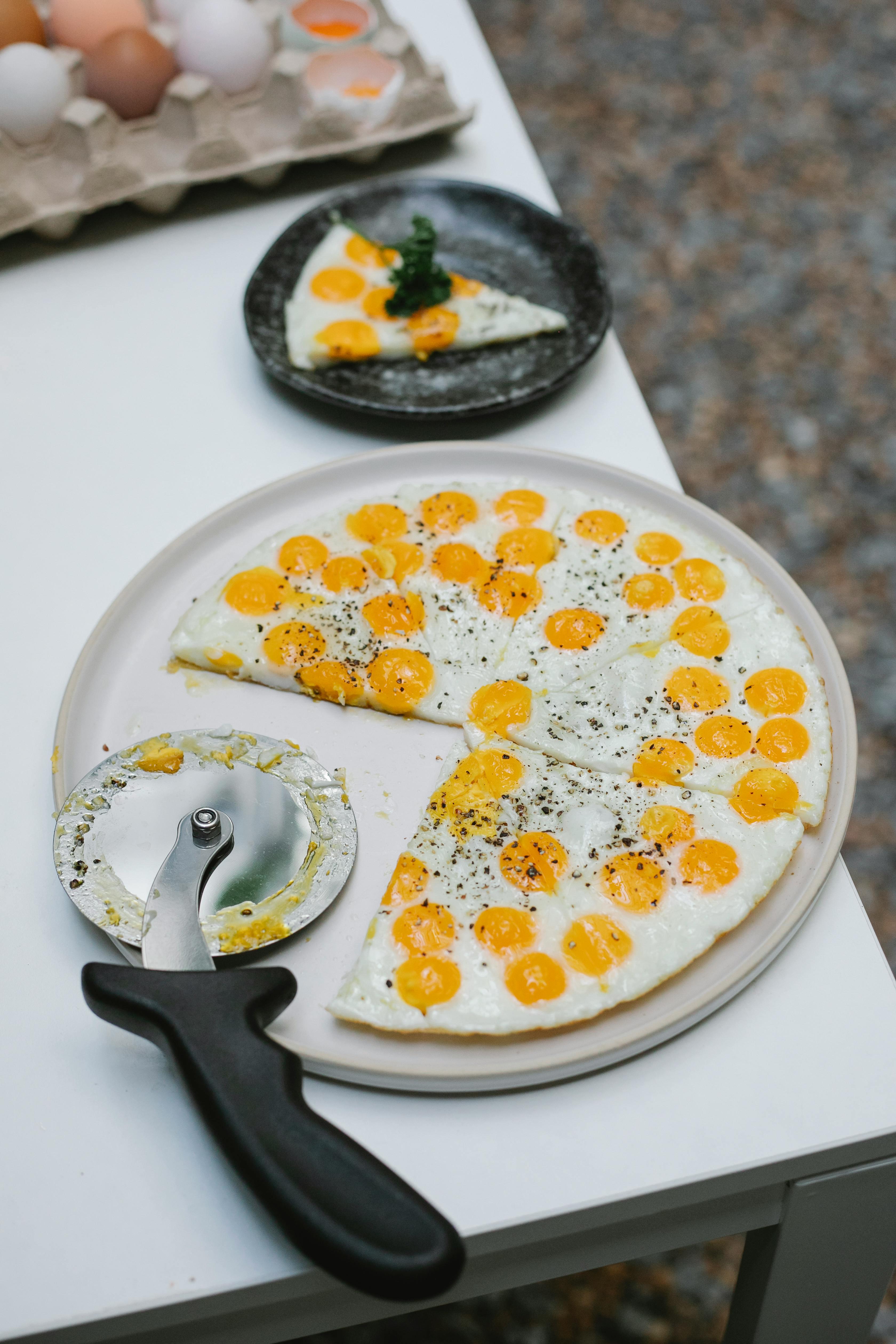 tasty fried eggs cut with pizza cutter