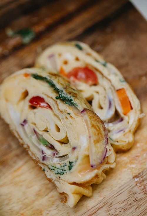 Free High angle yummy scrumptious egg roll with tomatoes and red onion cut in slices on wooden board Stock Photo