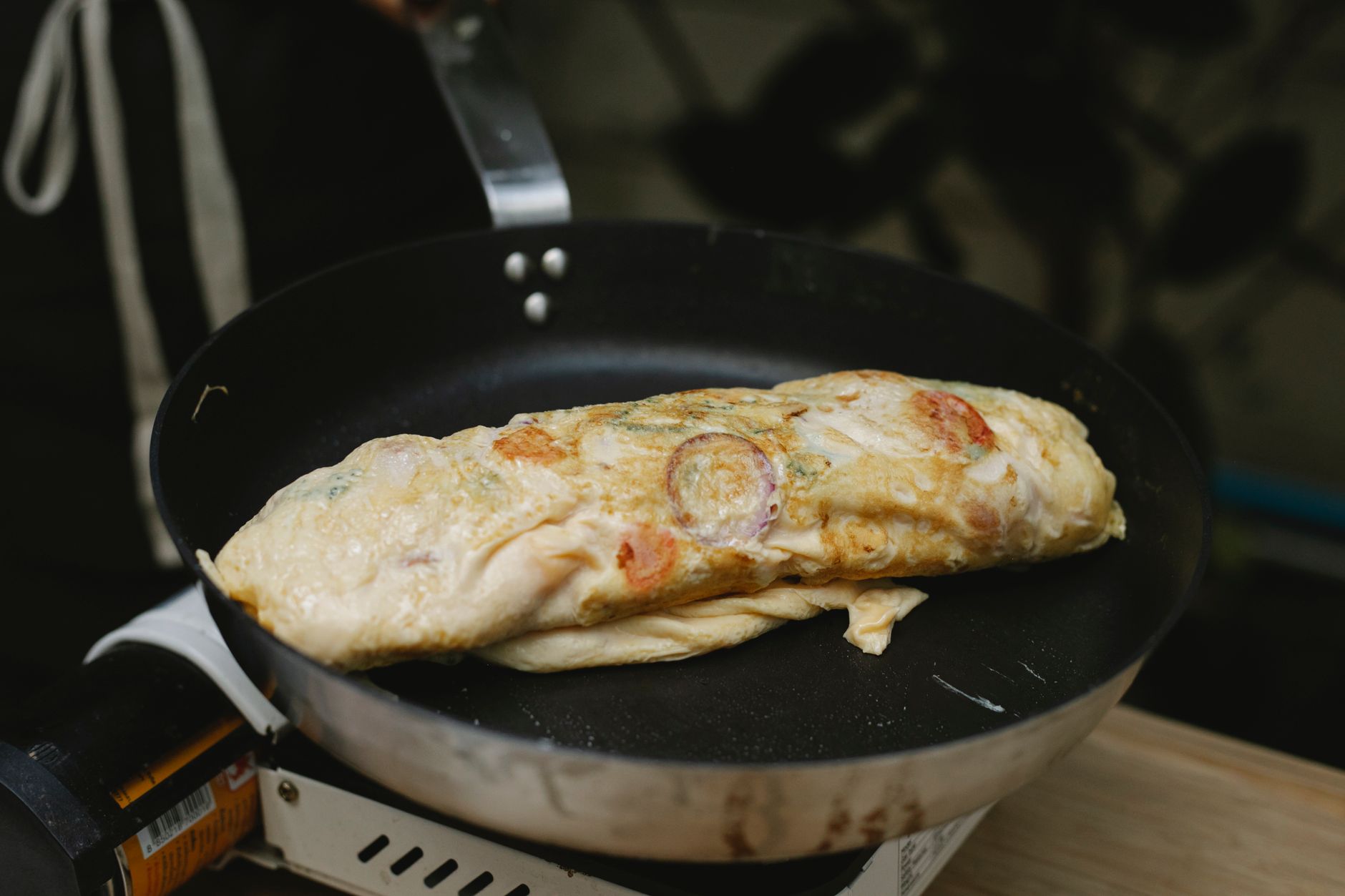 Golden Western omelette cooking in skillet with bell peppers and ham