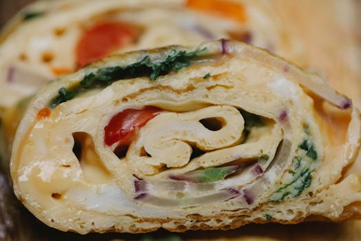 Sliced vegetarian omelette roll with fresh ingredients and vibrant colors.