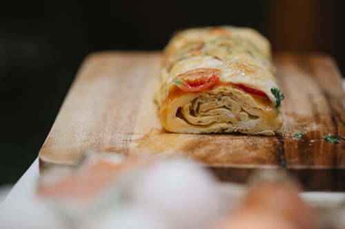 Free Appetizing yummy egg roll with ripe vegetables and fresh herbs placed on cutting board Stock Photo