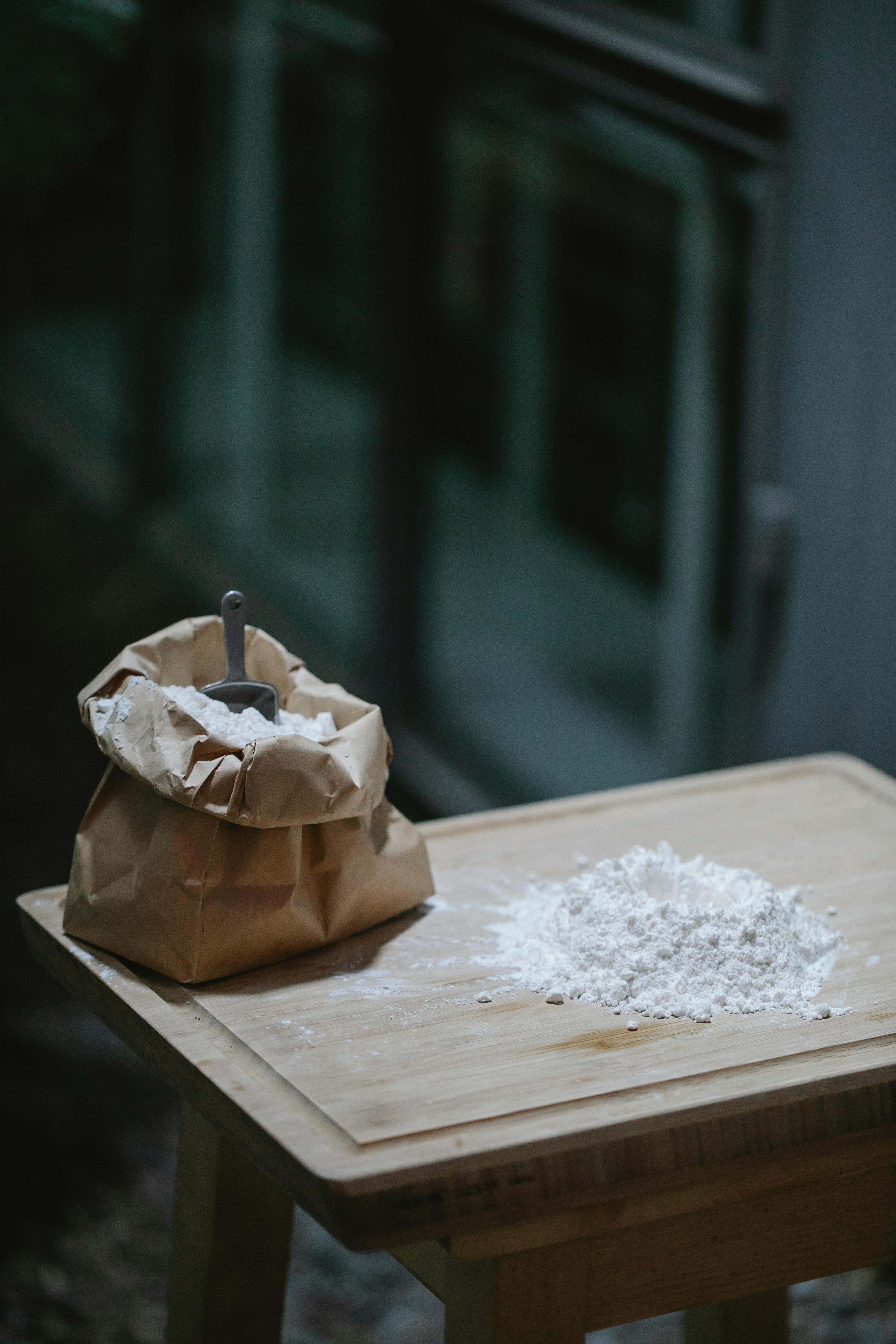 flour scattered on wooden table in kitchen