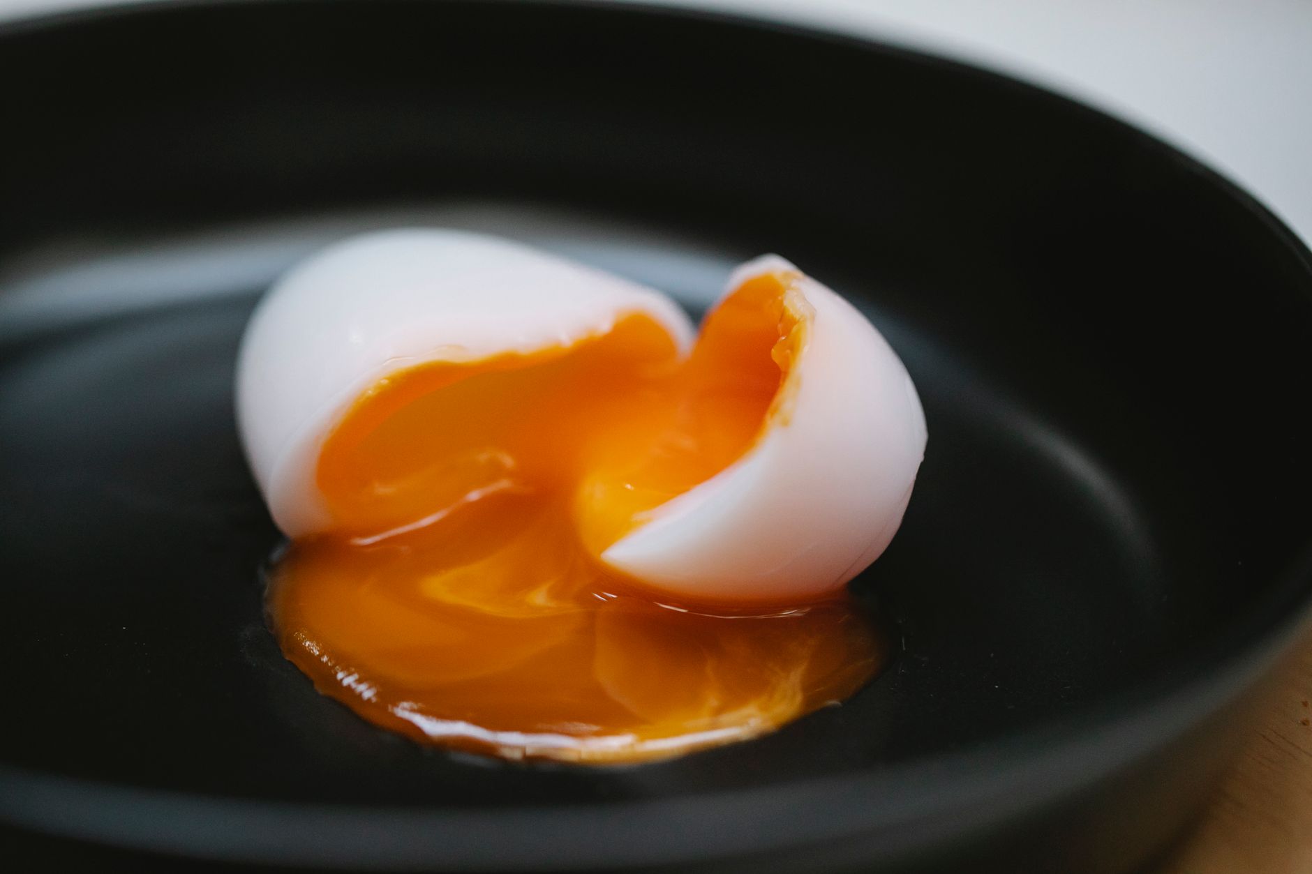 Soft boiled egg cut open over a slice of toast with avocado