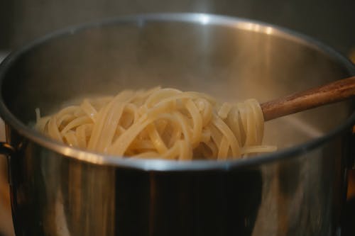 Metal pan with pasta in boiling water