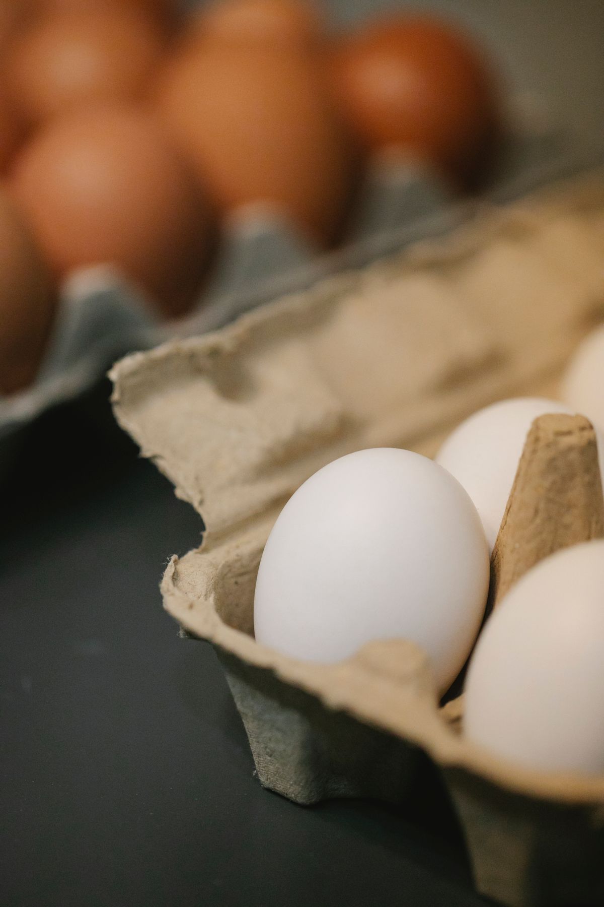 Ovos brancos e marrons organizados em embalagens