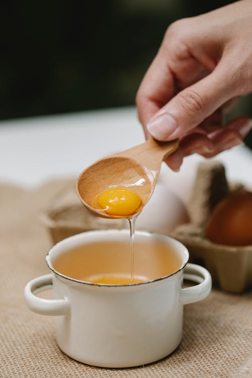 Female preparing eggs in small saucepan