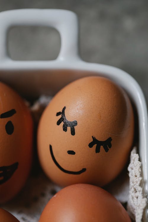 Brown chicken eggs with painted faces