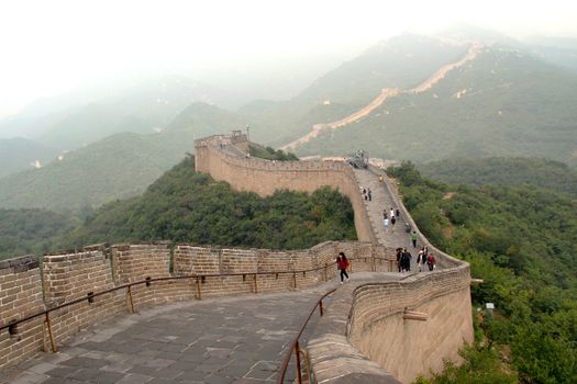 Discover the iconic Great Wall of China stretching through lush green mountains.