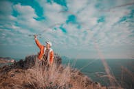 A Man in Orange Jacket Holding a Drone