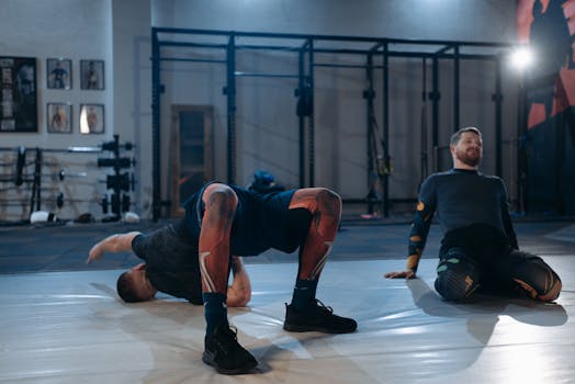 Two men engaged in stretching and core exercises on gym mats.