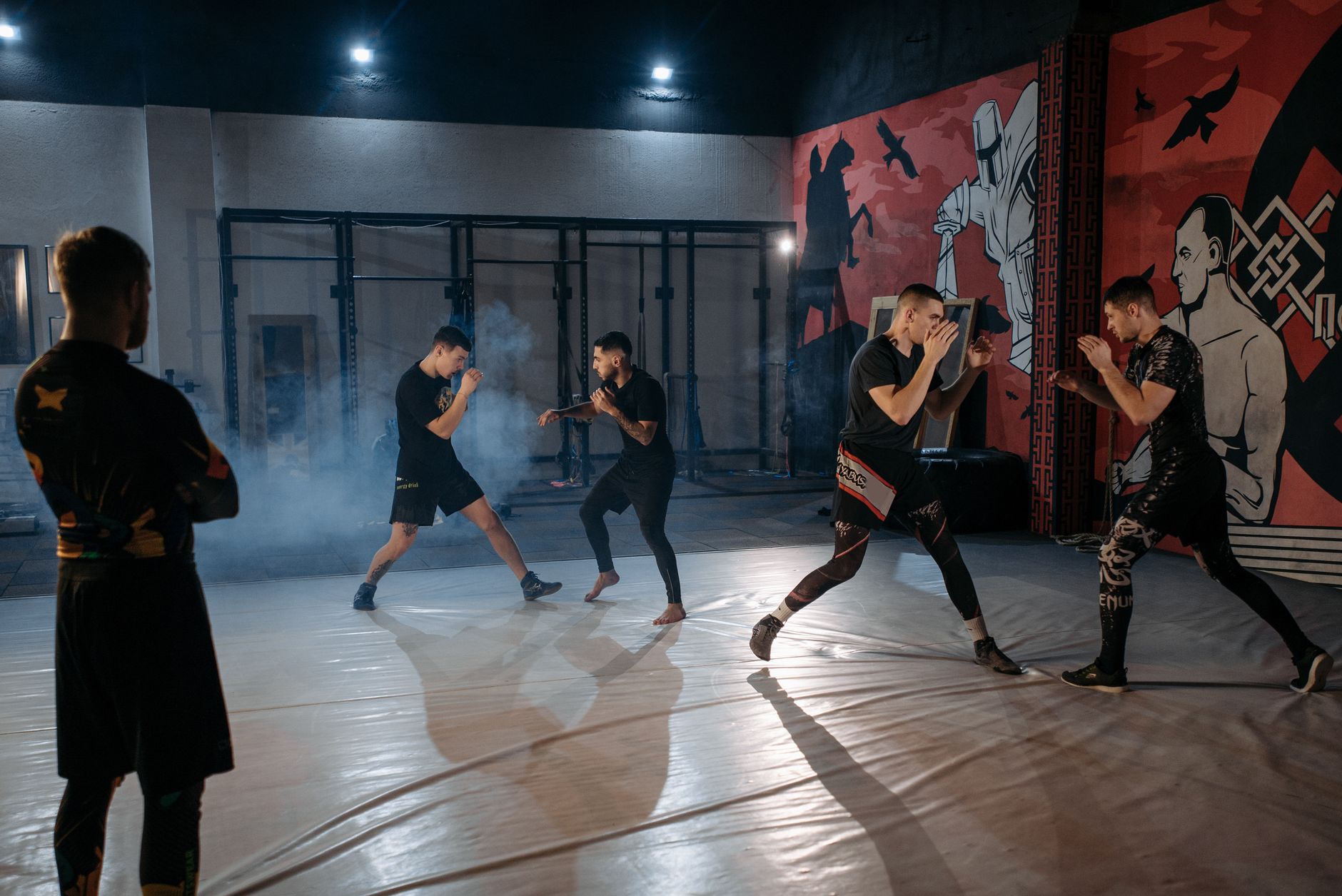 Group of men training in an MMA gym setting, focusing on sparring and techniques.