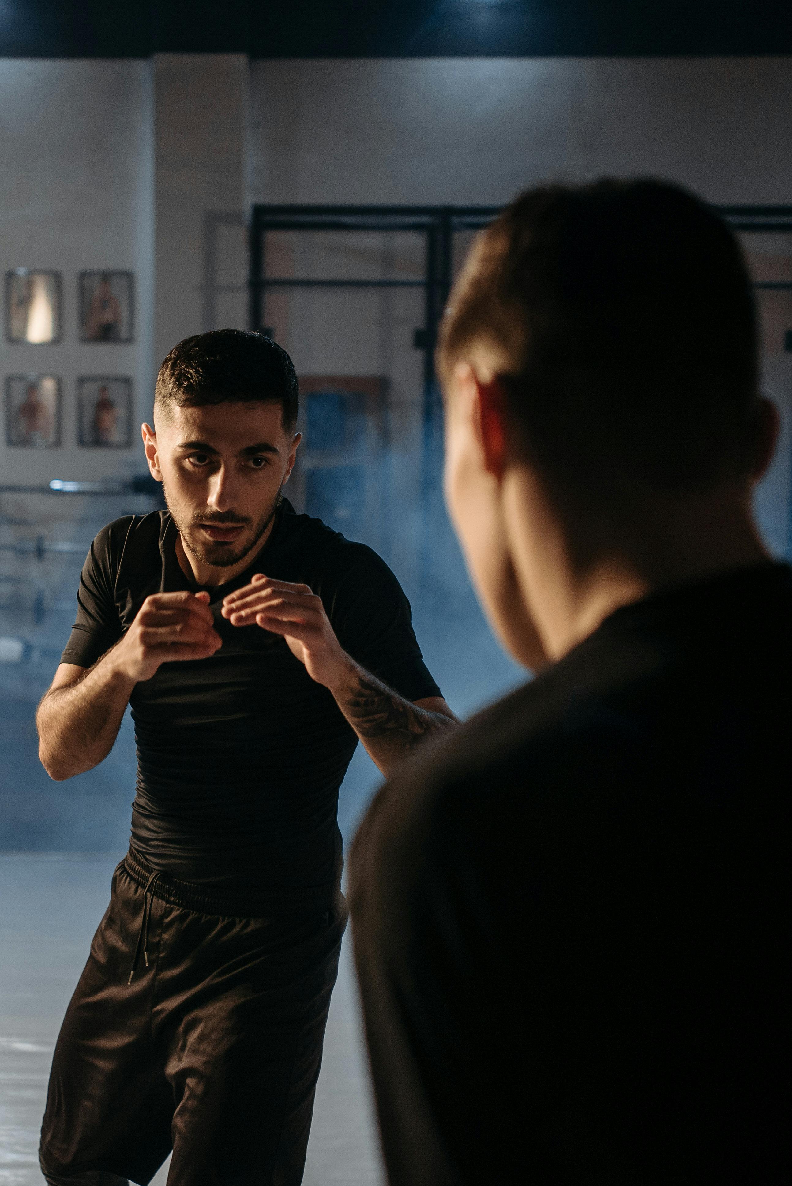 a man in black crew neck t shirt and shorts in boxing position