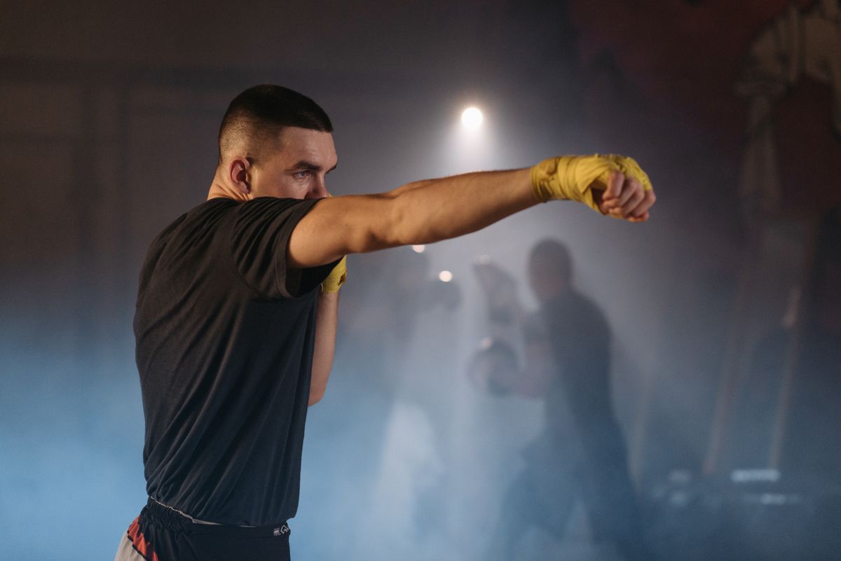 Boxer in yellow hand wraps throwing a punch during training