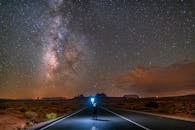 Man Standing on Empty Road Under Beautiful Sky