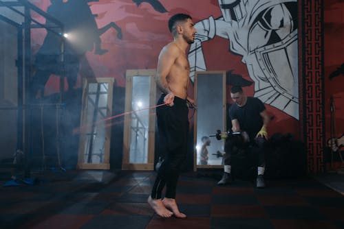 Side View of a Man Using a Jump Rope at a Gym