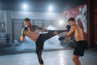 A Man Kicking another Man on The Face