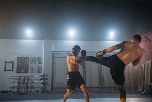 Free Two shirtless men sparring in a gym, showcasing kickboxing skills and physical fitness. Stock Photo