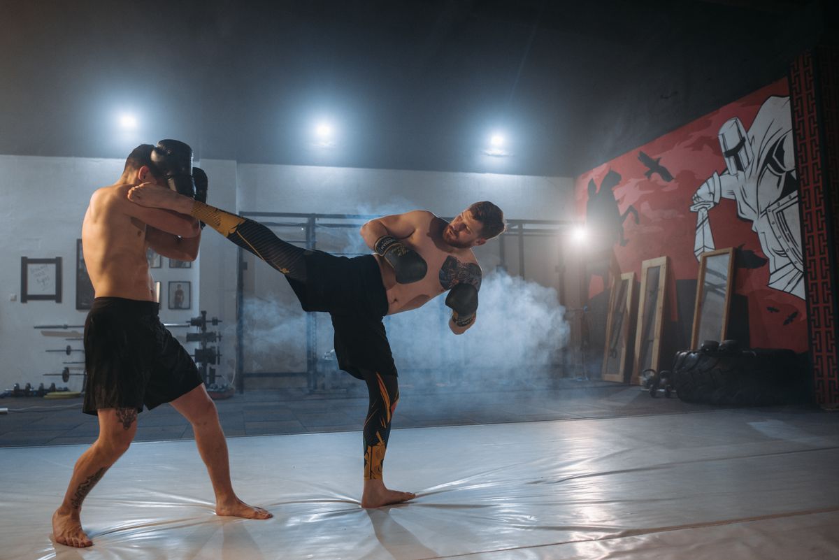 MMA fighter landing a high kick during gym training