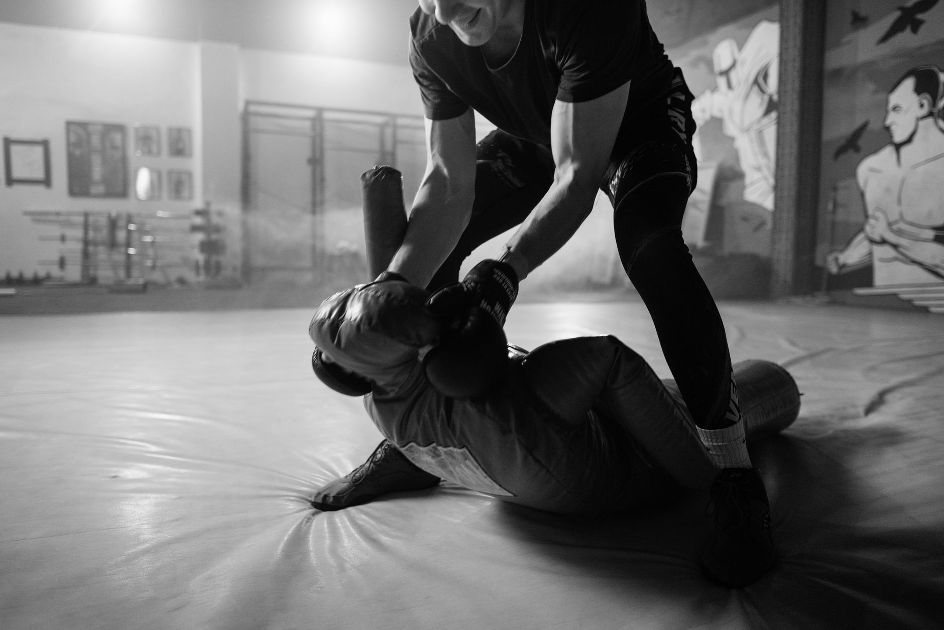 Men engage in a dynamic MMA training session, showcasing grappling techniques indoors.