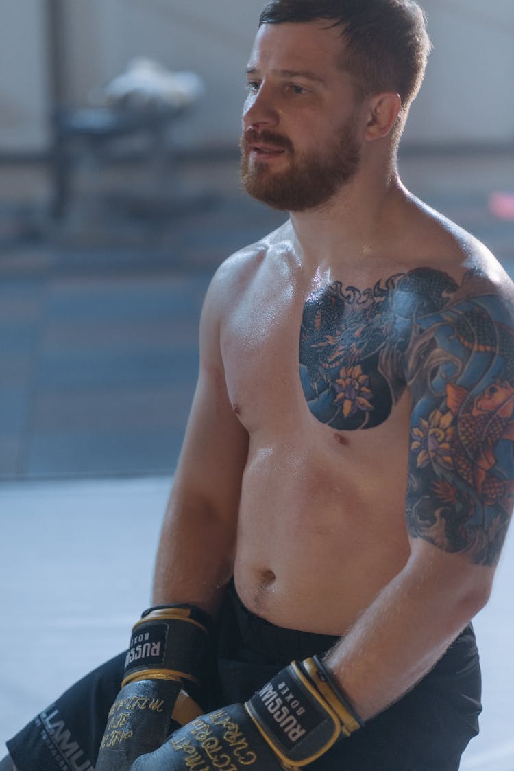 A Shirtless Man Wearing A Boxing Gloves