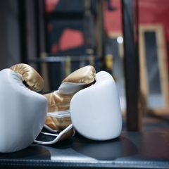 White and gold boxing gloves in a gym