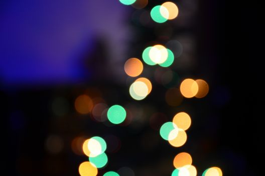 Colorful blurred lights forming bokeh circles against a dark background, evoking festive and dreamy feelings.