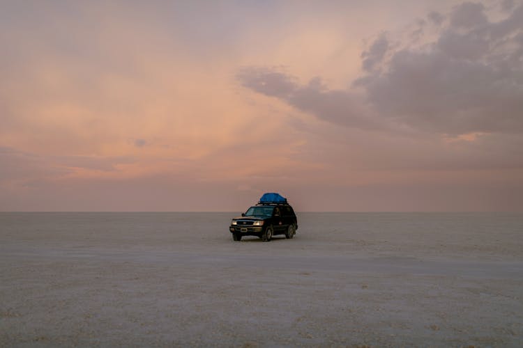 Car Driving In Empty Desert In Evening