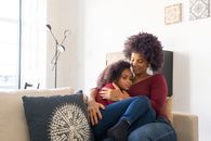 Woman in Red Long Sleeves Embracing the Girl Beside her