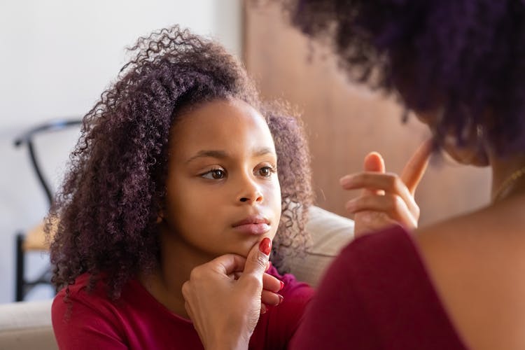 A Person Holding The Girl's Chin