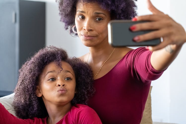 A Mother And Daughter Taking A Selfie