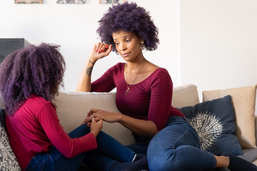 Mother and daughter bonding together on the couch at home