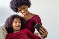 Mother and Daughter Taking a Selfie Sticking Their Tongues Out