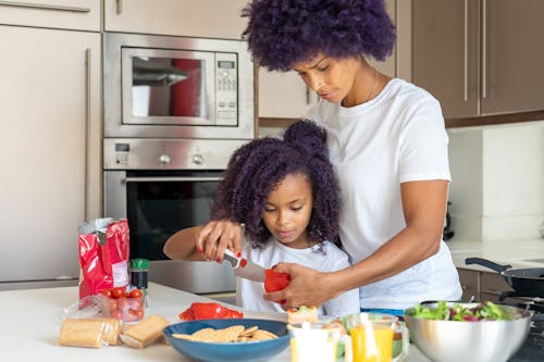 Free A Woman Preparing Food with her Daughter Stock Photo