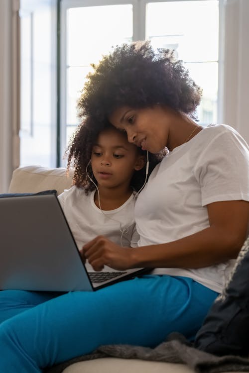 A Woman Using a Laptop with her Daughter