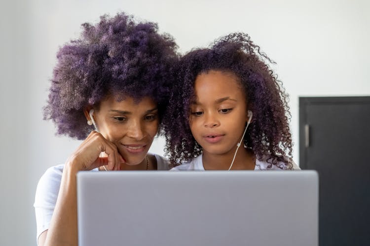 Photo Of A Woman And Her Daughter Looking At A Laptop