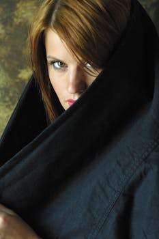 一幅神秘女子的肖像被黑色织物包裹，目光强烈