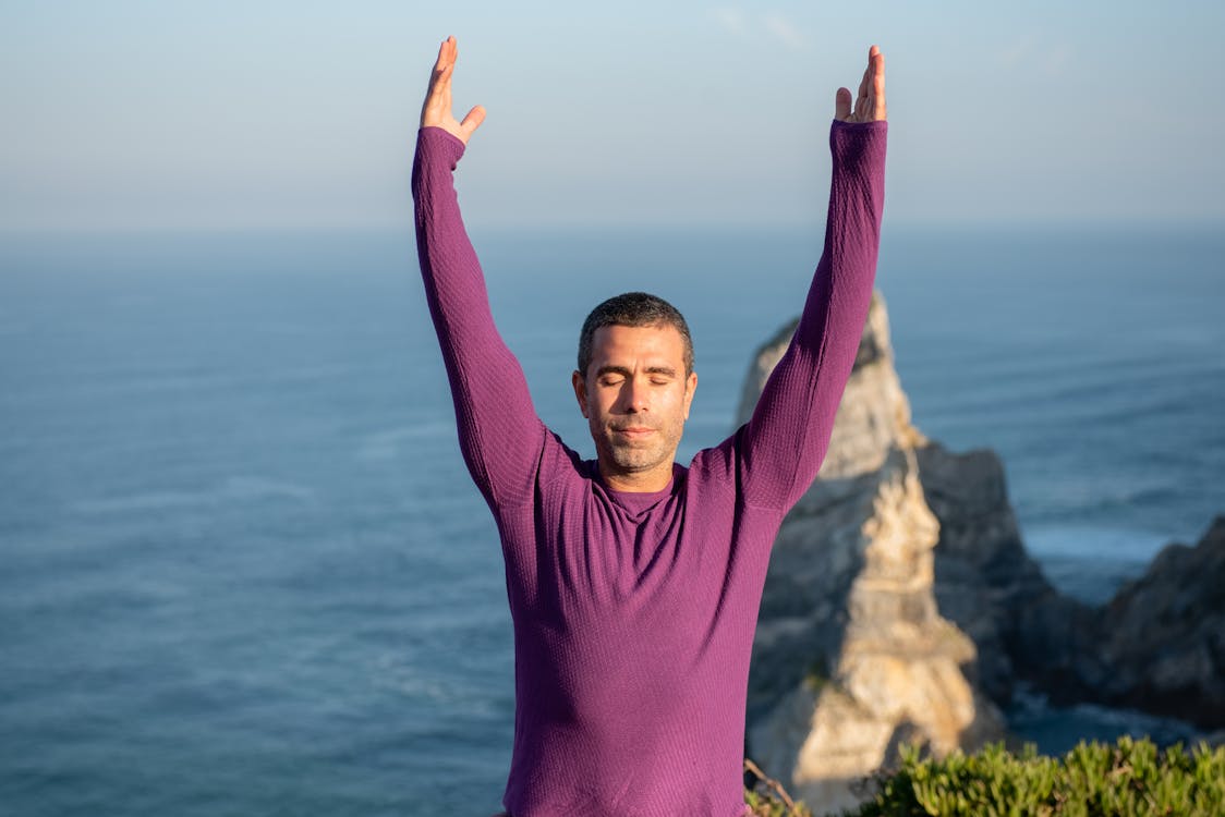 Man Raising his Hands while his Eyes Closed