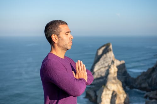 Free Man Meditating on Seaside Stock Photo