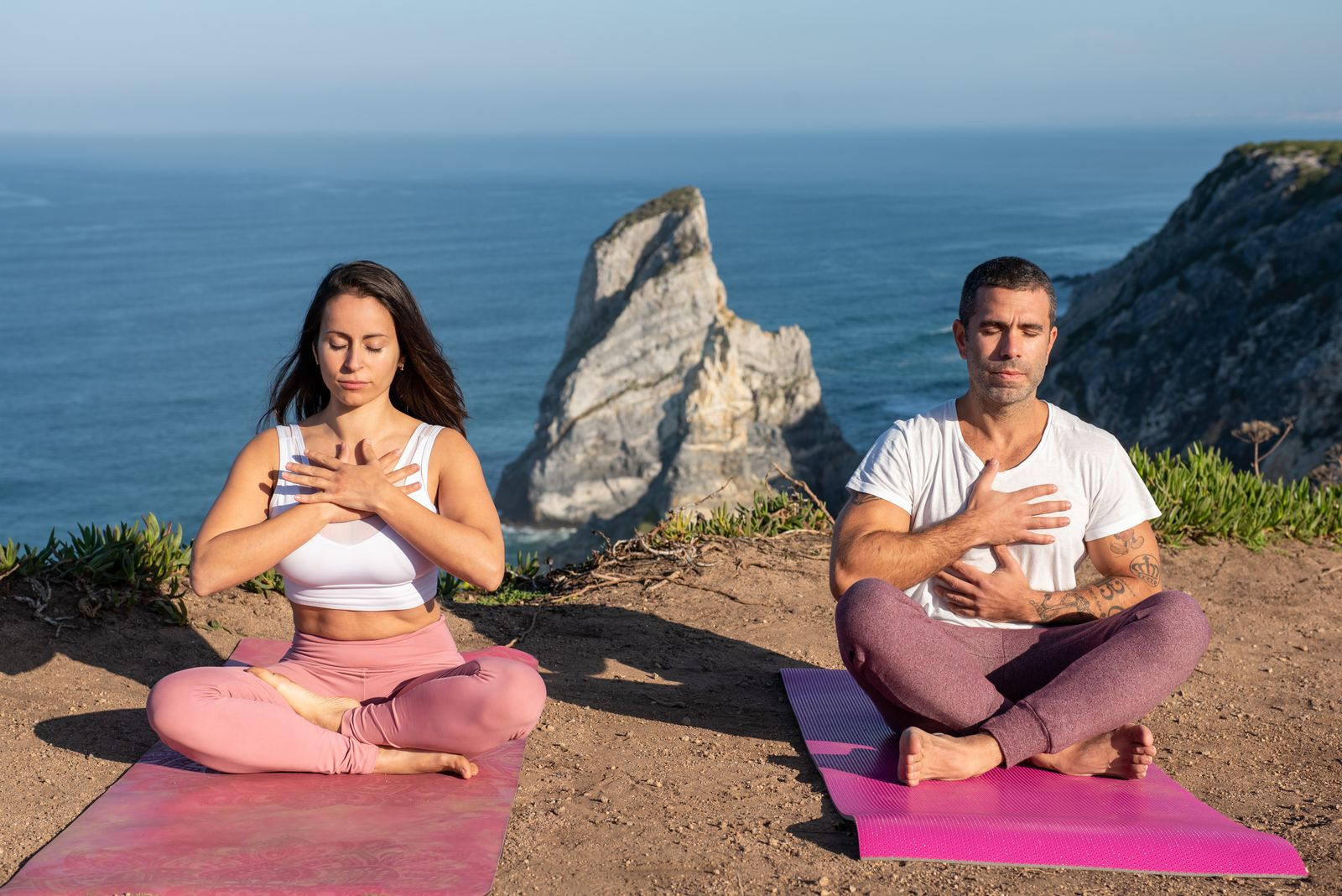 Two people practicing mindful yoga and breathing outdoors, reflecting the calm focus that follows a jal neti nasal-cleansing routine