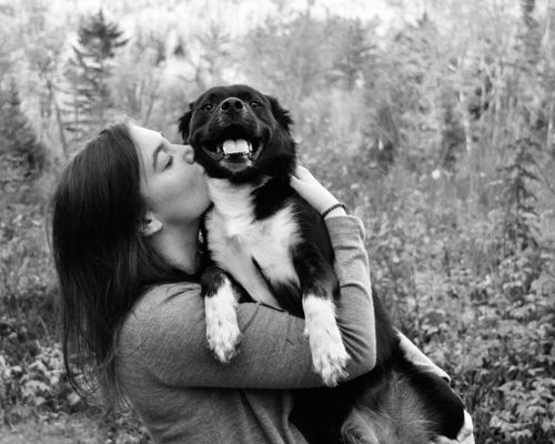 Free Black and white portrait of a woman hugging a dog outdoors, showcasing companionship. Stock Photo