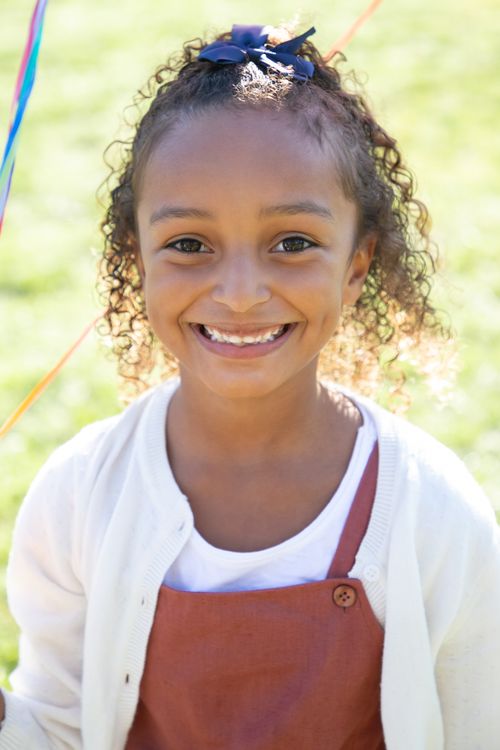 Free Joyful young girl smiling brightly while holding colorful balloons outdoors in Portugal. Stock Photo