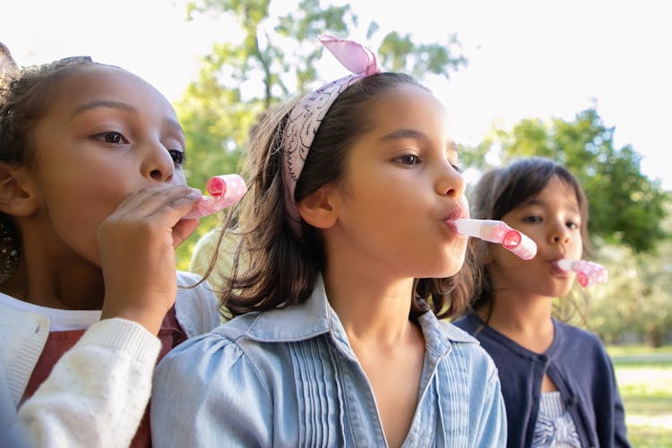 Kids Blowing On Whistle Toys