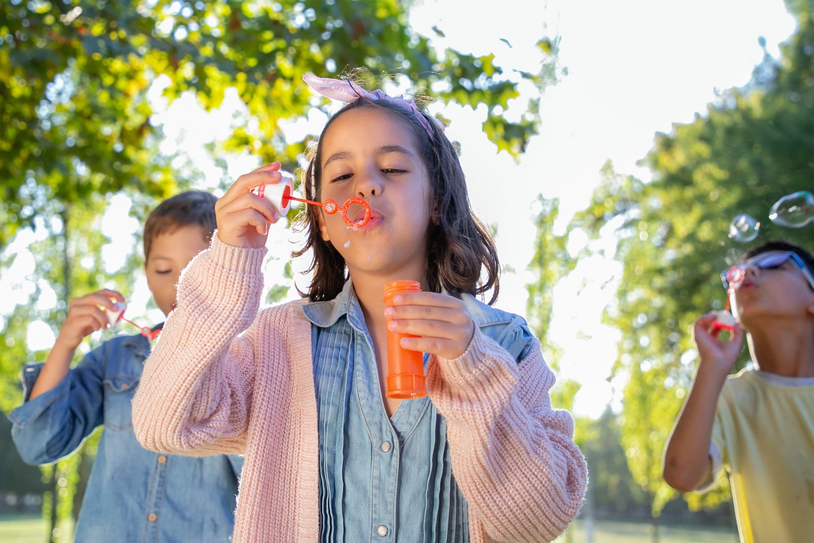 Bambini si divertono con le bolle di sapone in un parco