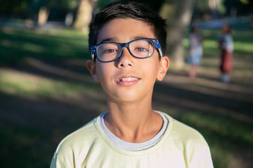 Close Up Photo of a Boy Wearing Eyeglasses