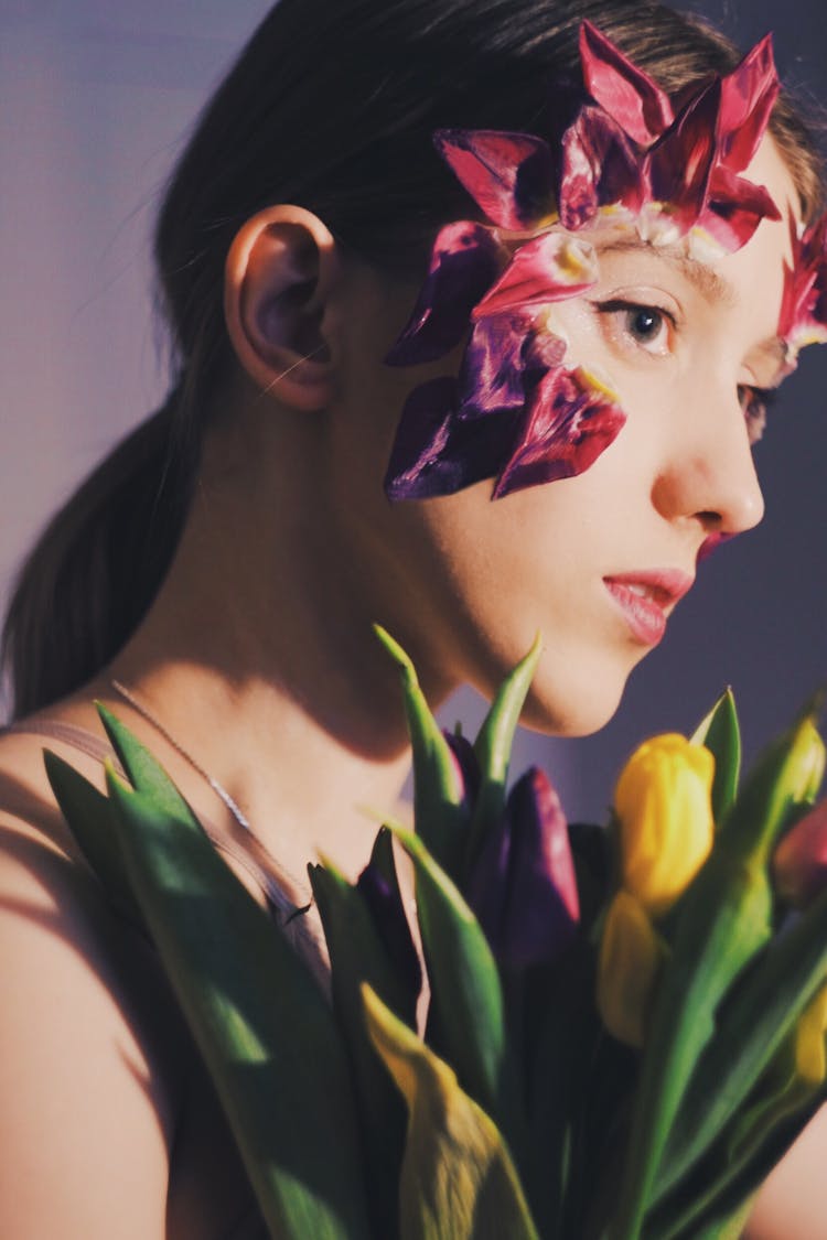 Crop Emotionless Woman With Tulip Flowers In Studio