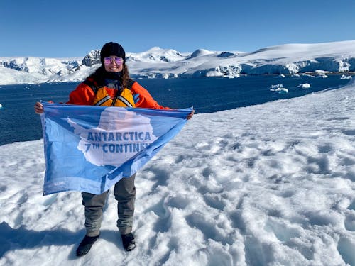 Frau In Der Schwarzen Jacke, Die Blaue Plastiktüte Auf Schneebedecktem Boden Hält