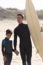 Man Holding the Hand of a Boy at the Beach